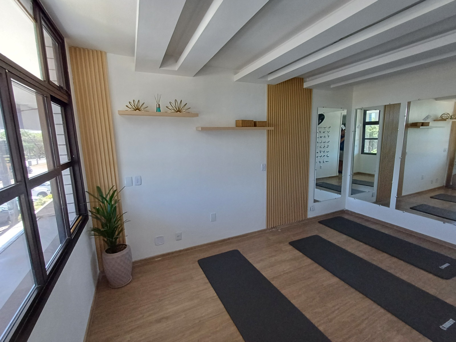 Sala de Mat Pilates com espelhos e painel de madeira